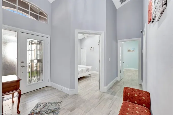 Front entry foyer featuring a decorative glass door, transom window, and tile flooring.