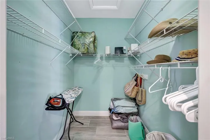 Walk-in closet with built-in wire shelving, overhead lighting, and ample storage space.