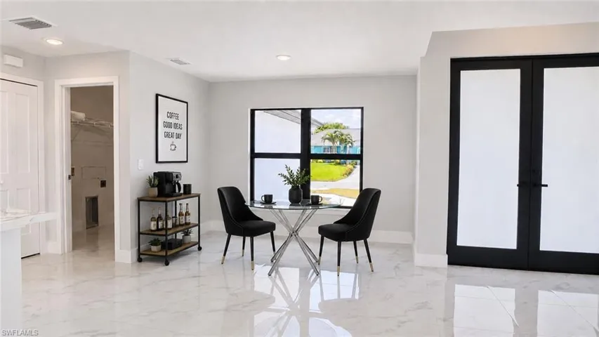 Bright interior space featuring white marble-look flooring, recessed lighting, and a large window with black framing