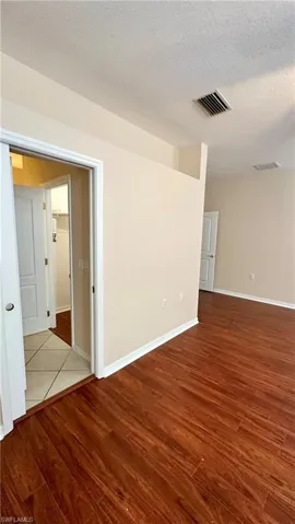 Spare room with wood finished floors and a textured ceiling