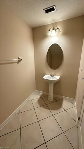 Bathroom featuring a textured ceiling and light tile patterned flooring