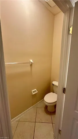Bathroom featuring light tile patterned floors and toilet