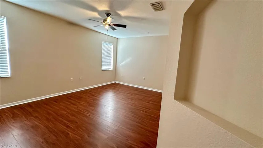 Spare room with dark wood-style flooring and ceiling fan