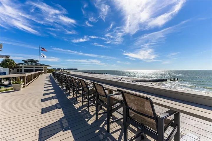 Deck with view of water and beach