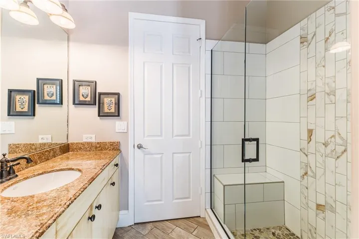 Full bathroom featuring vanity, a shower stall, and wood tiled floors