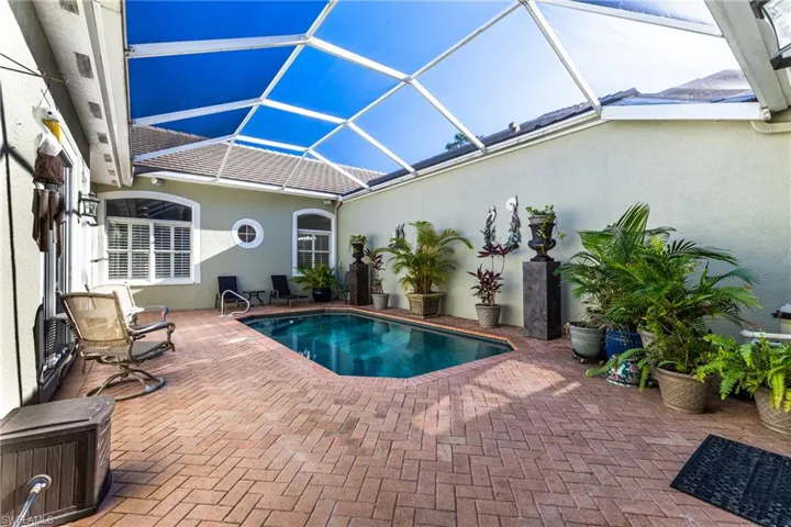 Outdoor pool featuring a screen enclosure, and a patio area