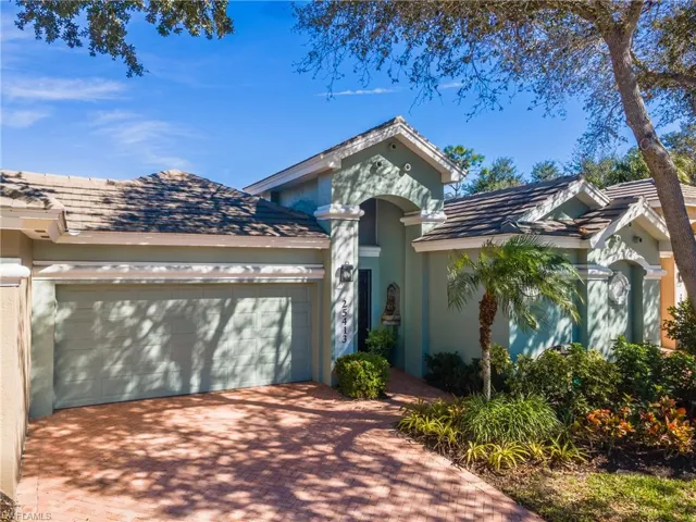 View of front facade with decorative driveway, a garage, and stucco siding