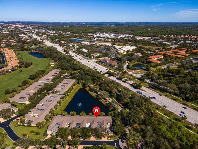 Aerial view of property's location featuring a large body of water and a golf course