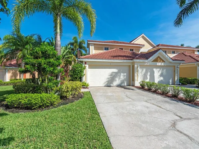 Coastal home featuring a 2-car garage, a gorgeous lawn, and a tile roof