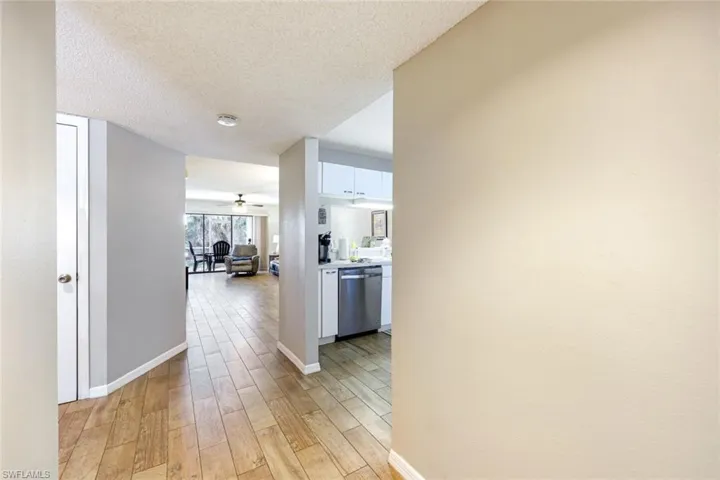 Hall with light wood finished floors and a textured ceiling