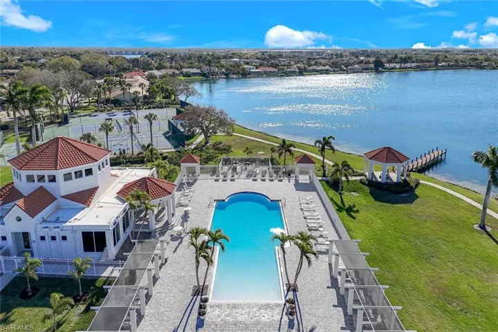 Drone / aerial view of a nearby body of water and a pool