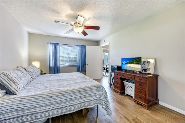 Bedroom with light wood-style flooring, a textured ceiling, and a ceiling fan