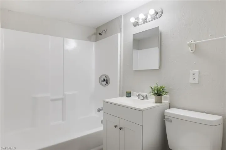 Full bathroom with vanity, tub / shower combination, and toilet