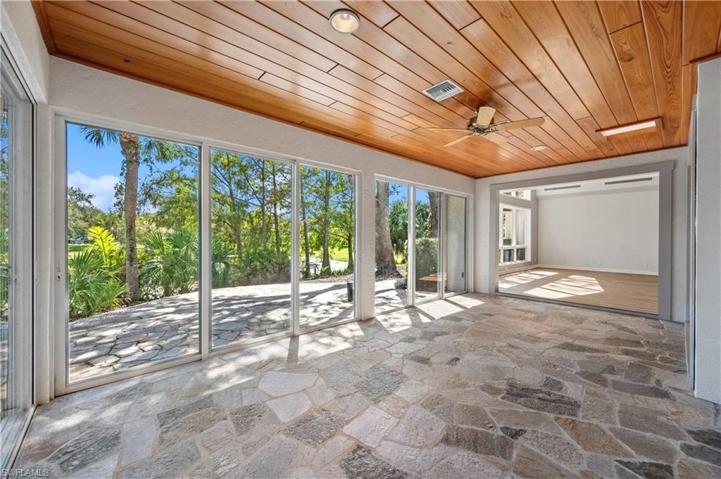 Sunroom brings the outdoors in with wall of sliders.