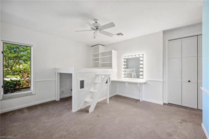 Whimsical bedroom with built-in platform bed & shelving.