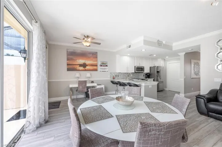 Dining area featuring ceiling fan, light hardwood / wood-style floors, sink, and ornamental molding