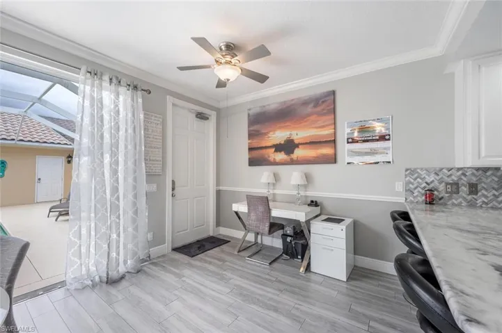 Office area with ornamental molding and ceiling fan