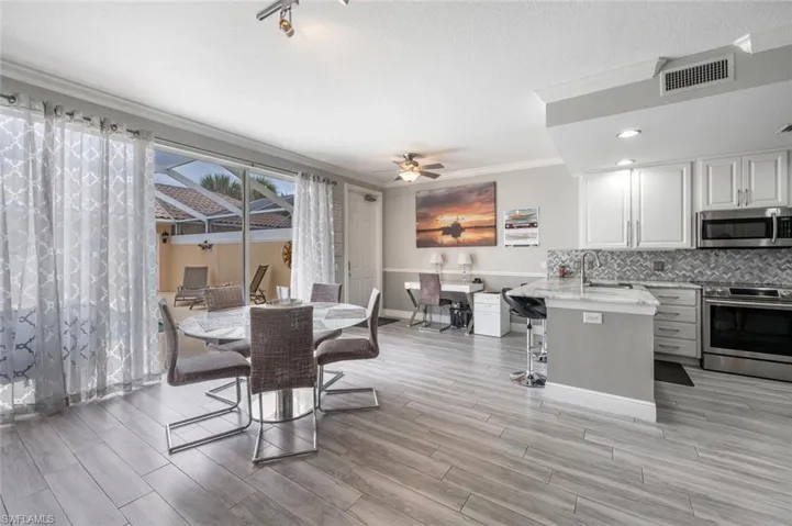 Dining space with sink, ceiling fan, and crown molding