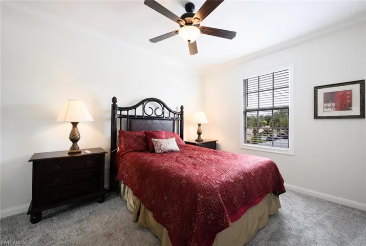 Carpeted bedroom with crown molding and ceiling fan