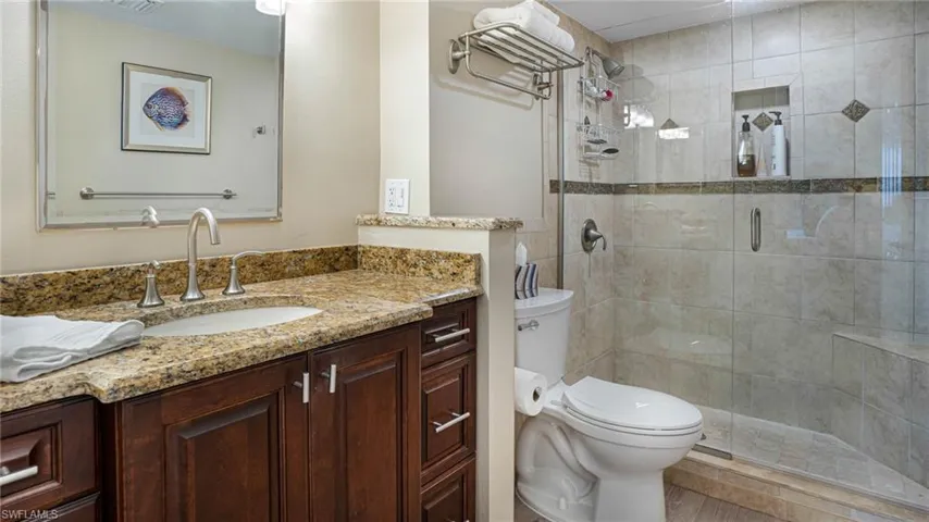 Bathroom with toilet, an enclosed shower, and vanity