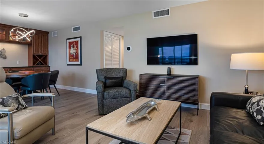 Living room featuring a notable chandelier and wood-type flooring