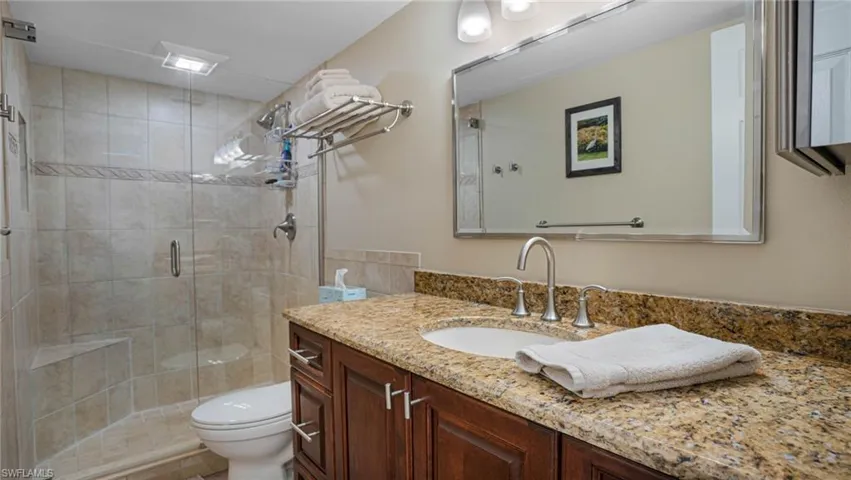 Bathroom with walk in shower, vanity, and toilet
