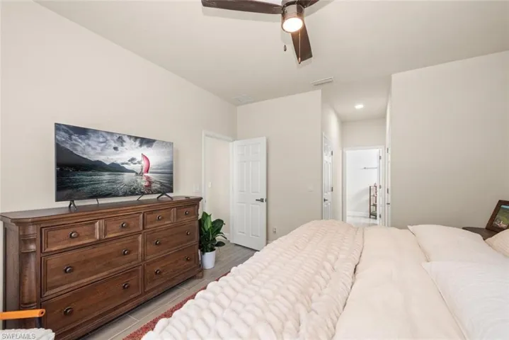 Bedroom featuring ensuite bath, a ceiling fan, and recessed lighting
