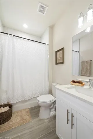 Bathroom featuring vanity and shower / bath combo with shower curtain