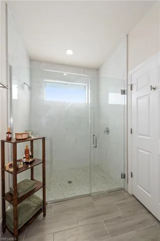 Bathroom featuring a marble finish shower