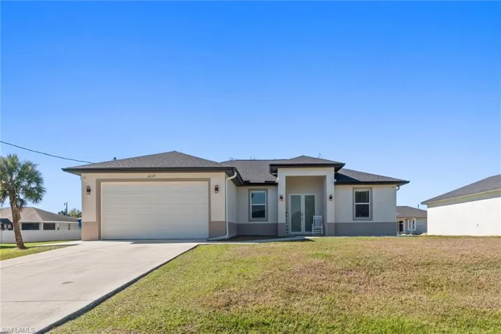 Prairie-style home featuring french doors, a front lawn, stucco siding, concrete driveway, and a garage