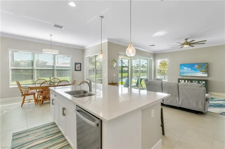 Kitchen with white cabinets, dishwasher, and pendant lighting