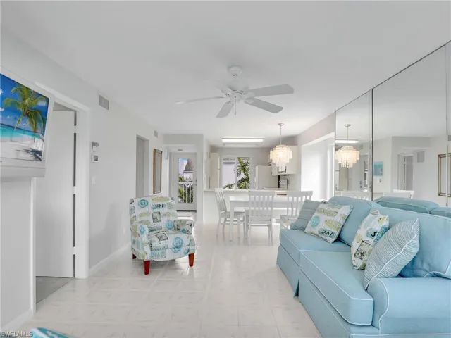 Living room with ceiling fan with notable chandelier