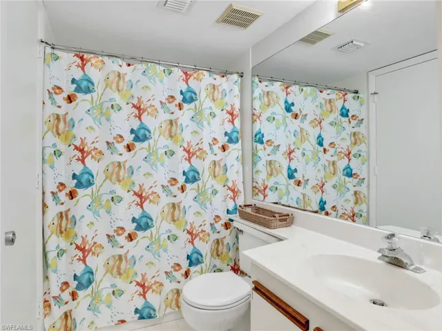Bathroom featuring tile patterned flooring, vanity, and toilet