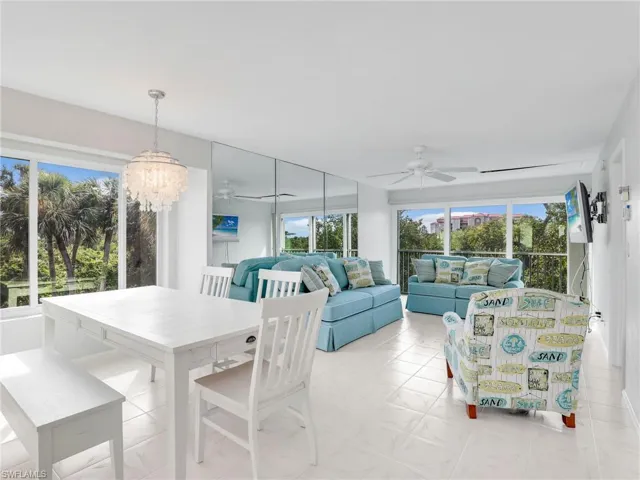 Dining space featuring ceiling fan with notable chandelier