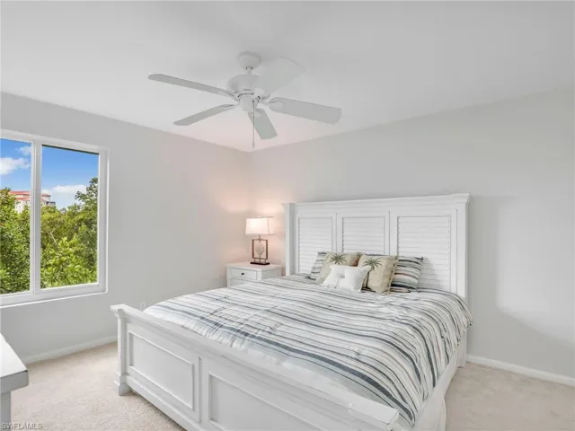 Carpeted bedroom featuring ceiling fan