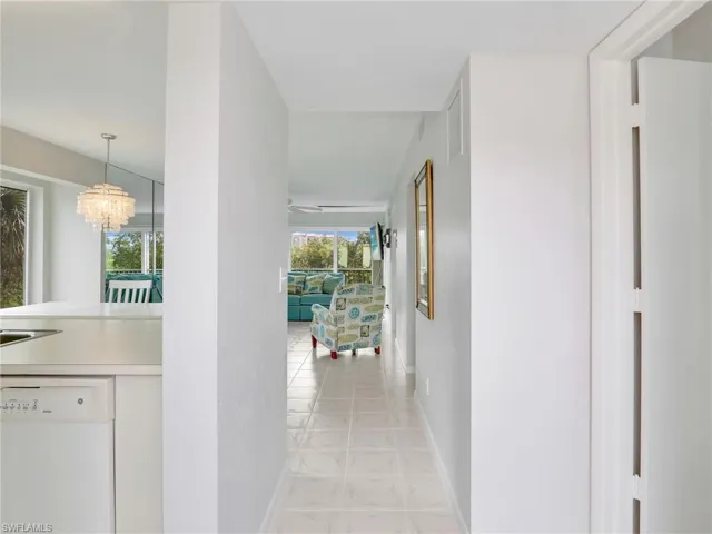 Corridor featuring an inviting chandelier