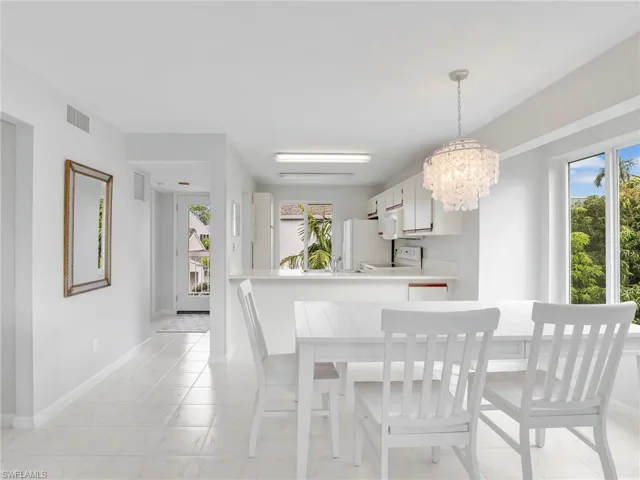 Dining space with light tile patterned floors and an inviting chandelier