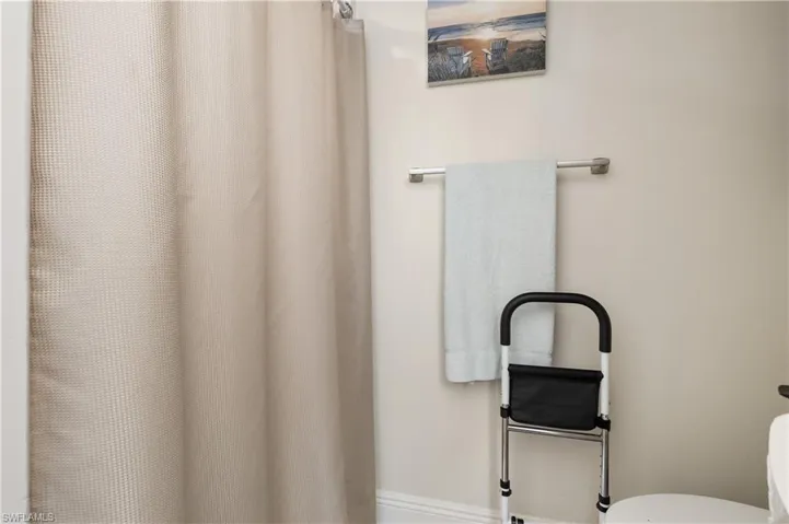 Full bath featuring a shower with shower curtain and toilet