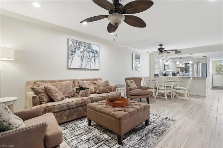 Living area featuring ornamental molding, light wood-type flooring, a ceiling fan, and recessed lighting
