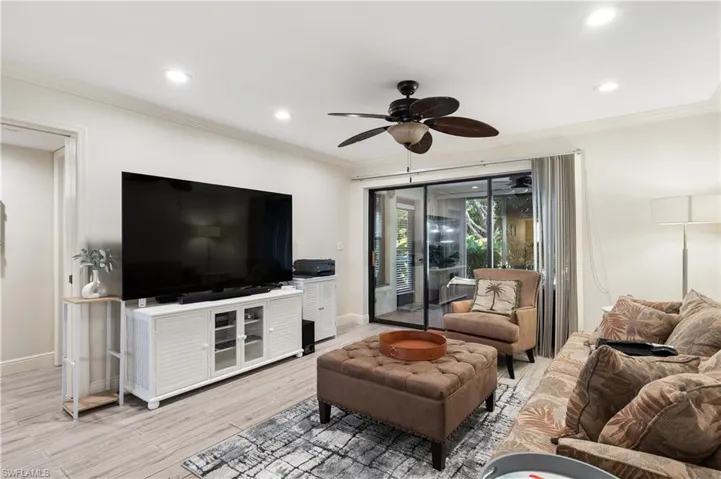 Living room featuring ceiling fan, light wood-type flooring, crown molding, and recessed lighting