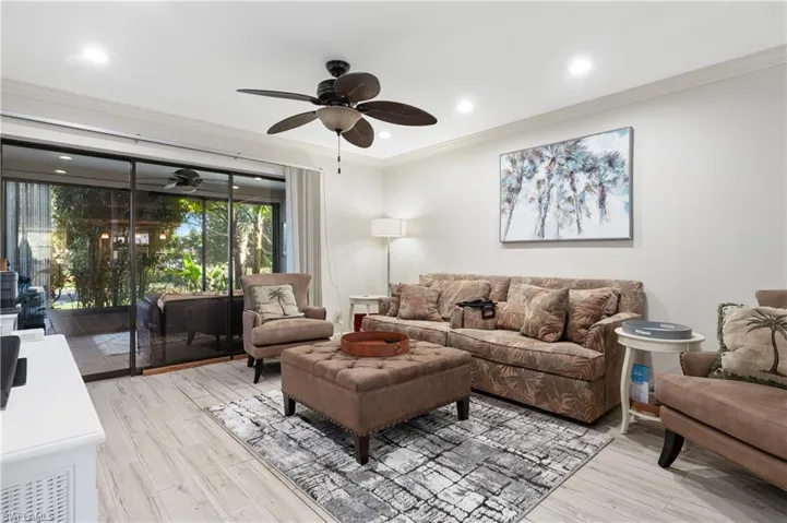 Living room with crown molding, a ceiling fan, light wood-type flooring, and recessed lighting
