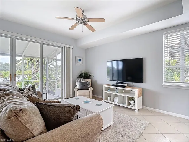 Living room with ceiling fan and light tile patterned flooring