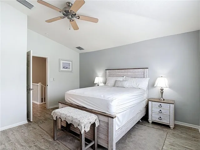 Bedroom with vaulted ceiling, ceiling fan, and light wood-style flooring
