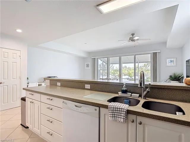 Kitchen featuring white cabinets, white dishwasher, light stone counters, light tile patterned floors, and recessed lighting