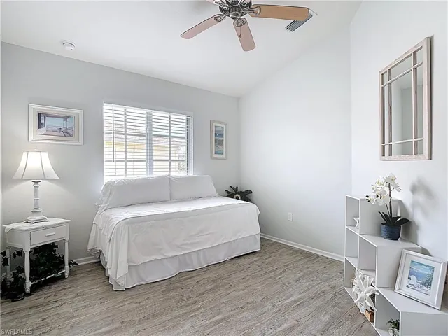 Bedroom featuring light wood finished floors, ceiling fan, and vaulted ceiling