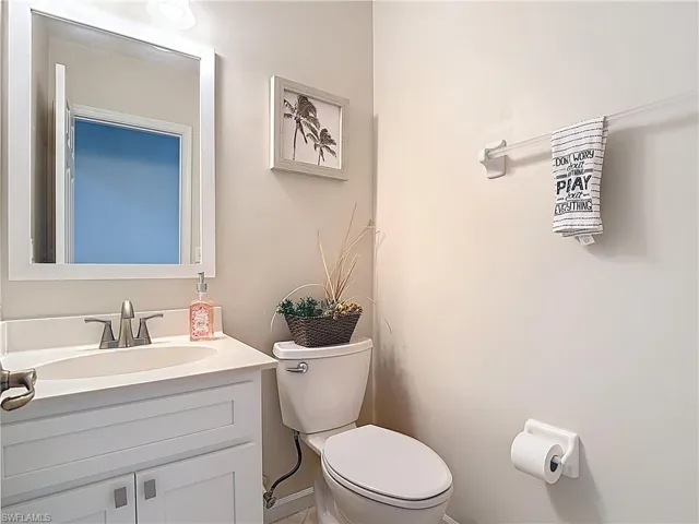 Half bathroom with vanity and toilet