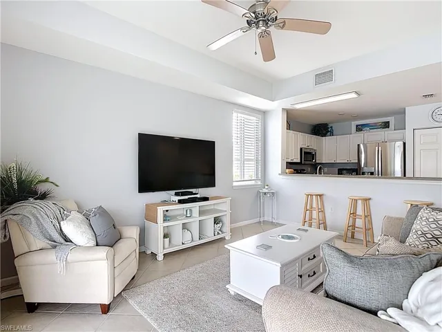 Living area featuring light tile patterned flooring and ceiling fan