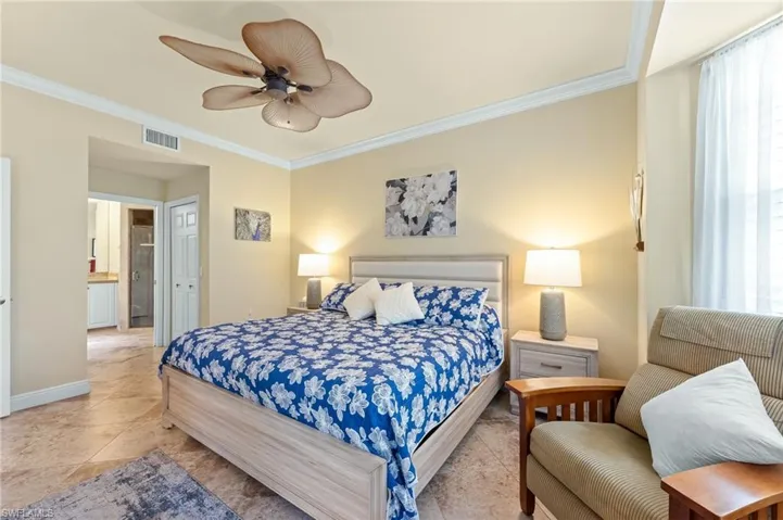 Bedroom featuring crown molding, a closet, ceiling fan, ensuite bathroom, and multiple windows