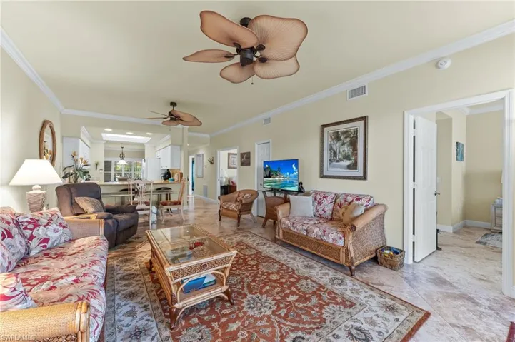 Living area featuring ornamental molding and a ceiling fan
