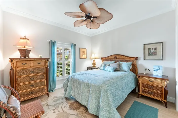 Bedroom featuring crown molding, wood finished floors, and a ceiling fan